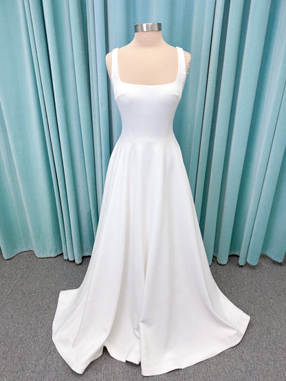 A-Line Ivory wedding dress on mannequin with square neckline and matte crepe A-line skirt