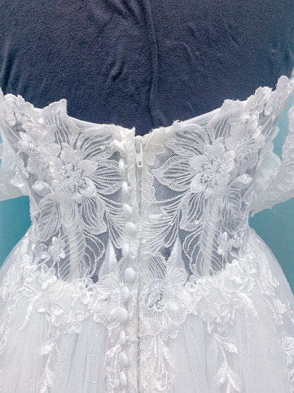 Morilee 2979 Filippa A-line wedding dress in glitter tulle with plunge sweetheart bodice, sequin beaded threadwork appliqués, detachable off-shoulder straps, and front slit.