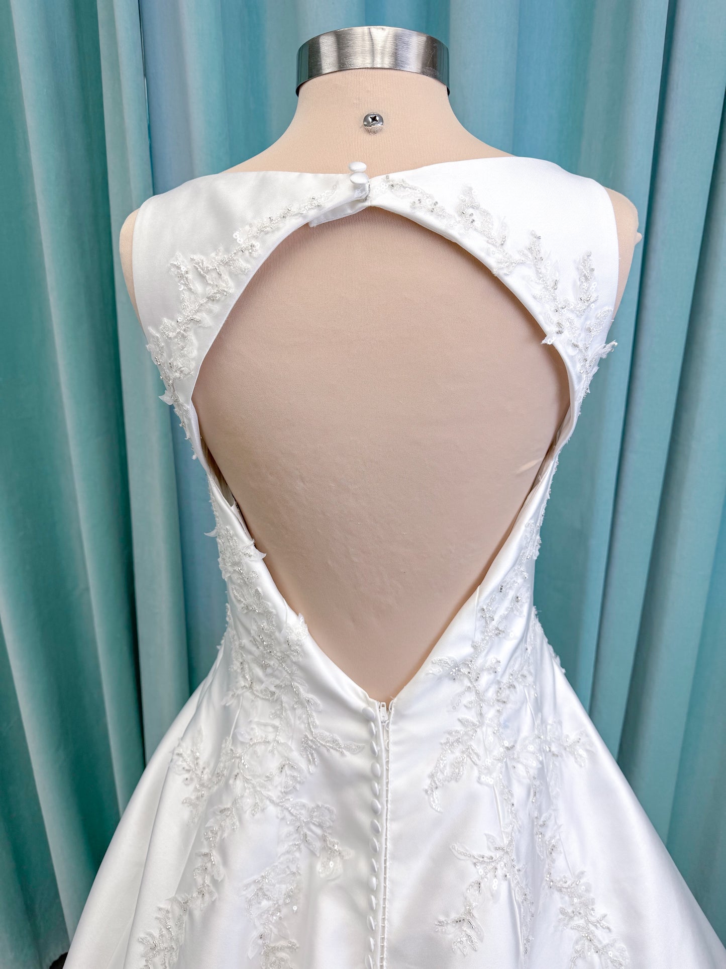 Morilee 1050018 Glissade A-line wedding dress on mannequin with high neckline, 3D floral lace appliques, satin, and beading