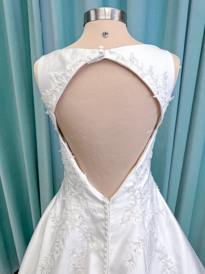 Morilee 1050018 Glissade A-line wedding dress on mannequin with high neckline, 3D floral lace appliques, satin, and beading