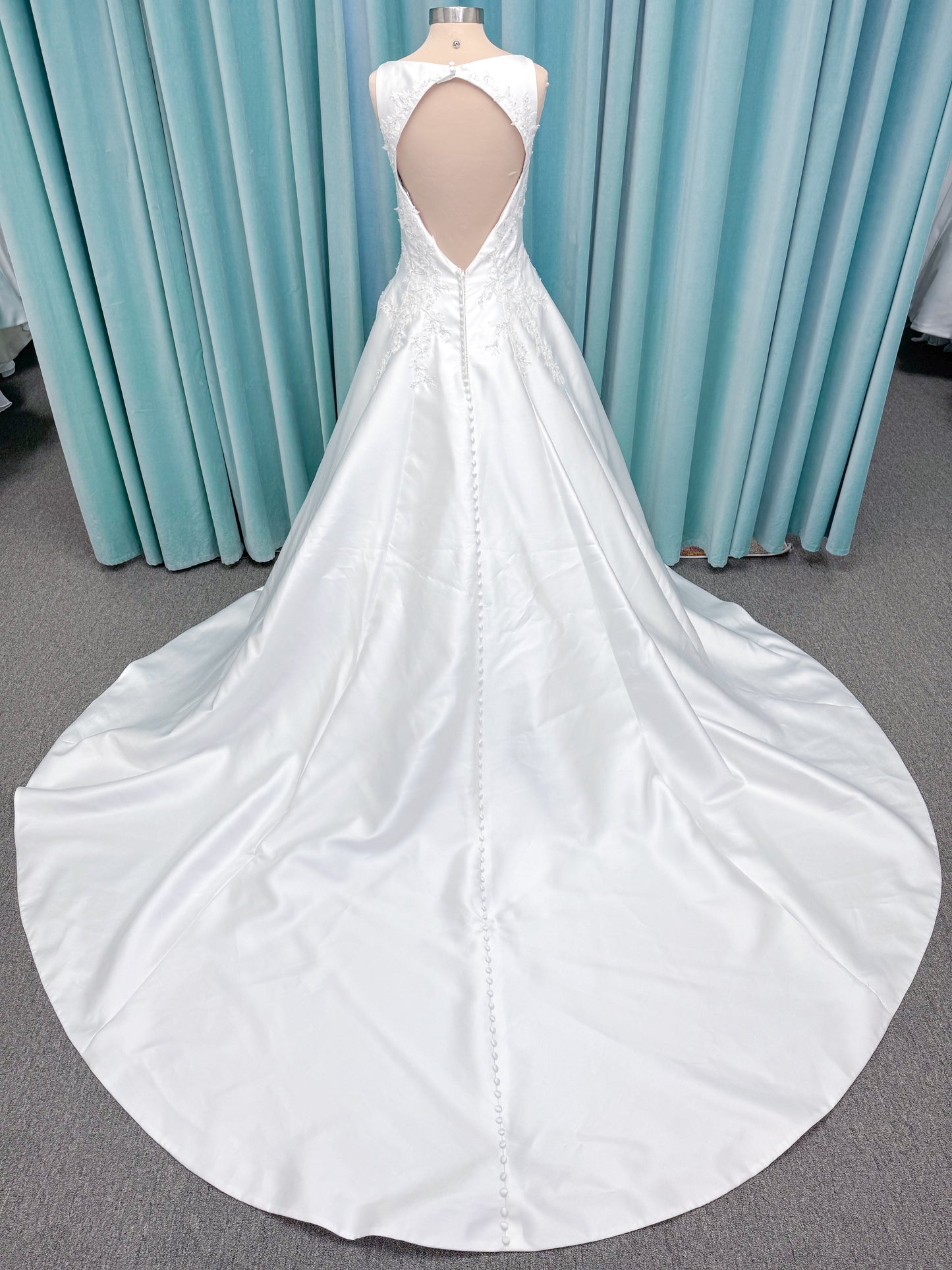 Morilee 1050018 Glissade A-line wedding dress on mannequin with high neckline, 3D floral lace appliques, satin, and beading