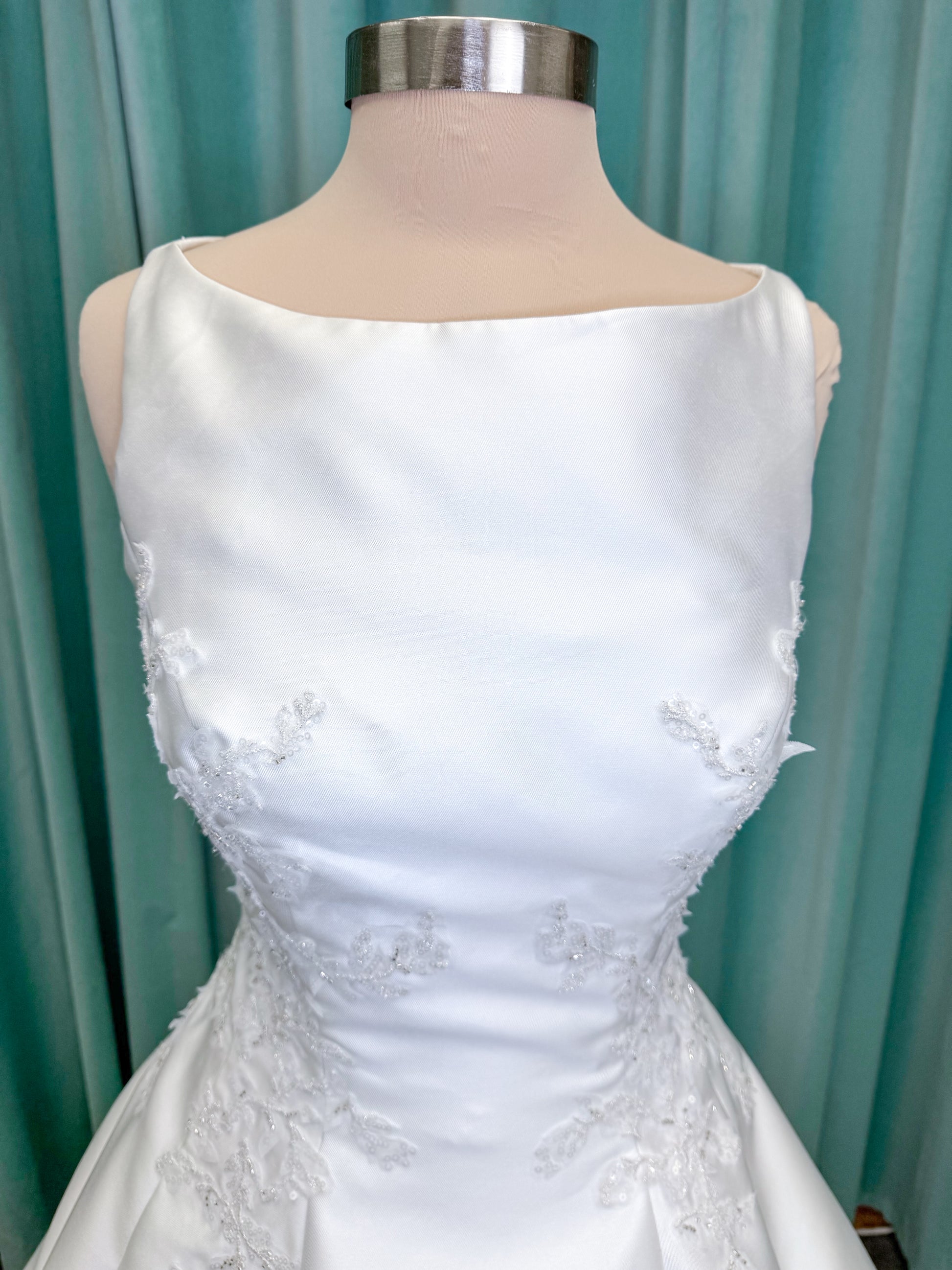 Morilee 1050018 Glissade A-line wedding dress on mannequin with high neckline, 3D floral lace appliques, satin, and beading