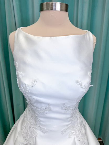 Morilee 1050018 Glissade A-line wedding dress on mannequin with high neckline, 3D floral lace appliques, satin, and beading