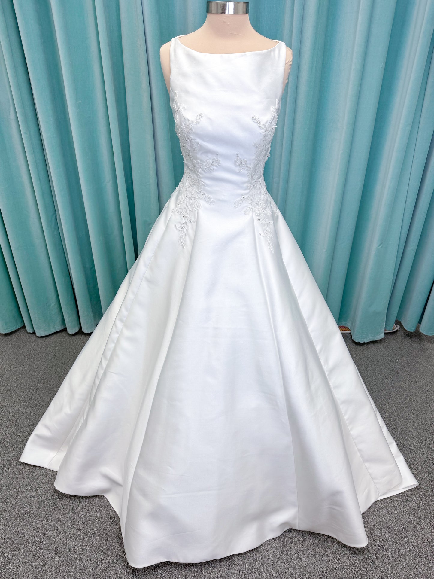 Morilee 1050018 Glissade A-line wedding dress on mannequin with high neckline, 3D floral lace appliques, satin, and beading