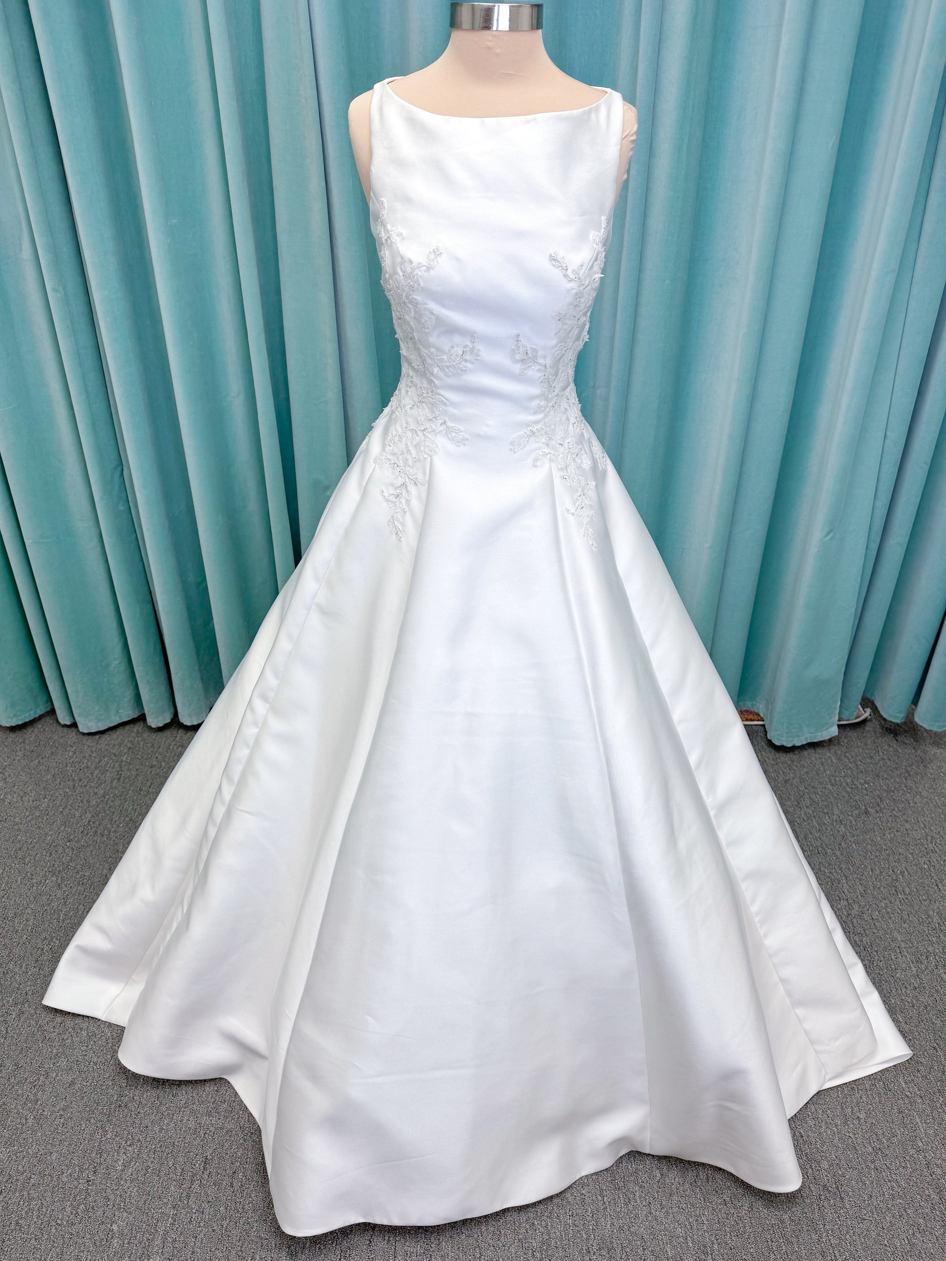 Morilee 1050018 Glissade A-line wedding dress on mannequin with high neckline, 3D floral lace appliques, satin, and beading