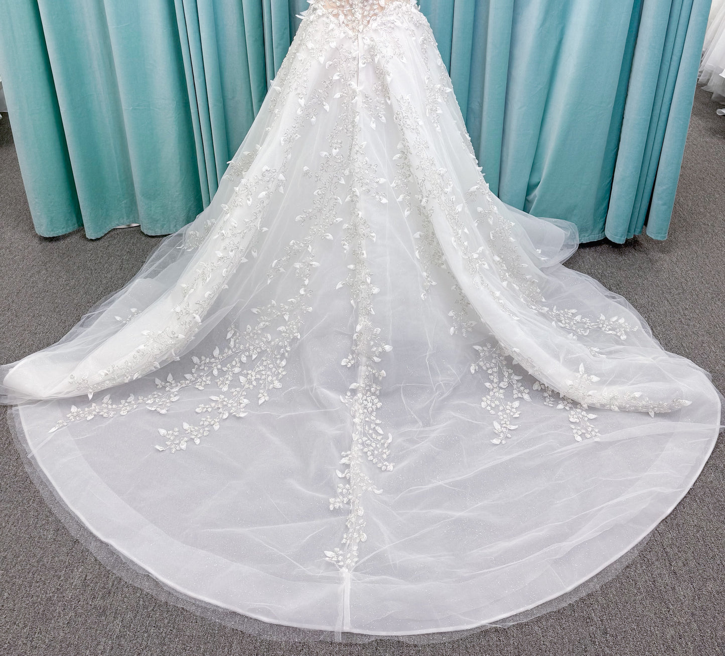 Randy Fenoli Goddess ballgown wedding dress on mannequin with plunging sweetheart neckline, 3D leaf appliqué, basque waist, high skirt slit, and sparkle tulle skirt