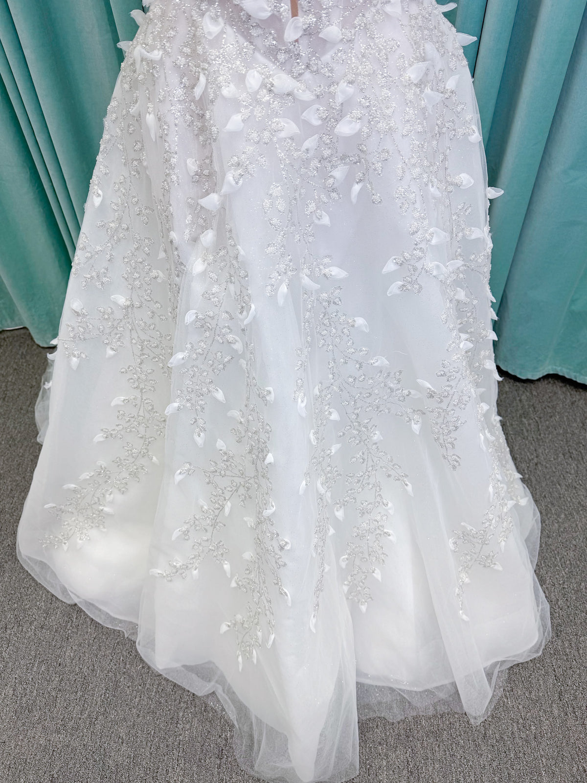 Randy Fenoli Goddess ballgown wedding dress on mannequin with plunging sweetheart neckline, 3D leaf appliqué, basque waist, high skirt slit, and sparkle tulle skirt