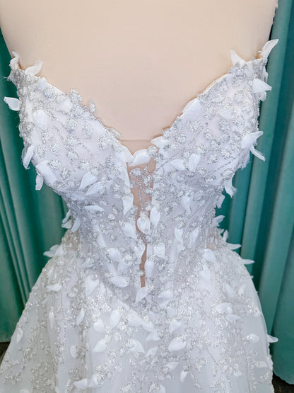 Randy Fenoli Goddess ballgown wedding dress on mannequin with plunging sweetheart neckline, 3D leaf appliqué, basque waist, high skirt slit, and sparkle tulle skirt
