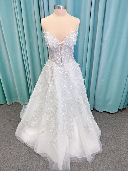 Randy Fenoli Goddess ballgown wedding dress on mannequin with plunging sweetheart neckline, 3D leaf appliqué, basque waist, high skirt slit, and sparkle tulle skirt