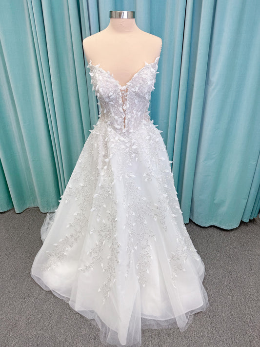 Randy Fenoli Goddess ballgown wedding dress on mannequin with plunging sweetheart neckline, 3D leaf appliqué, basque waist, high skirt slit, and sparkle tulle skirt
