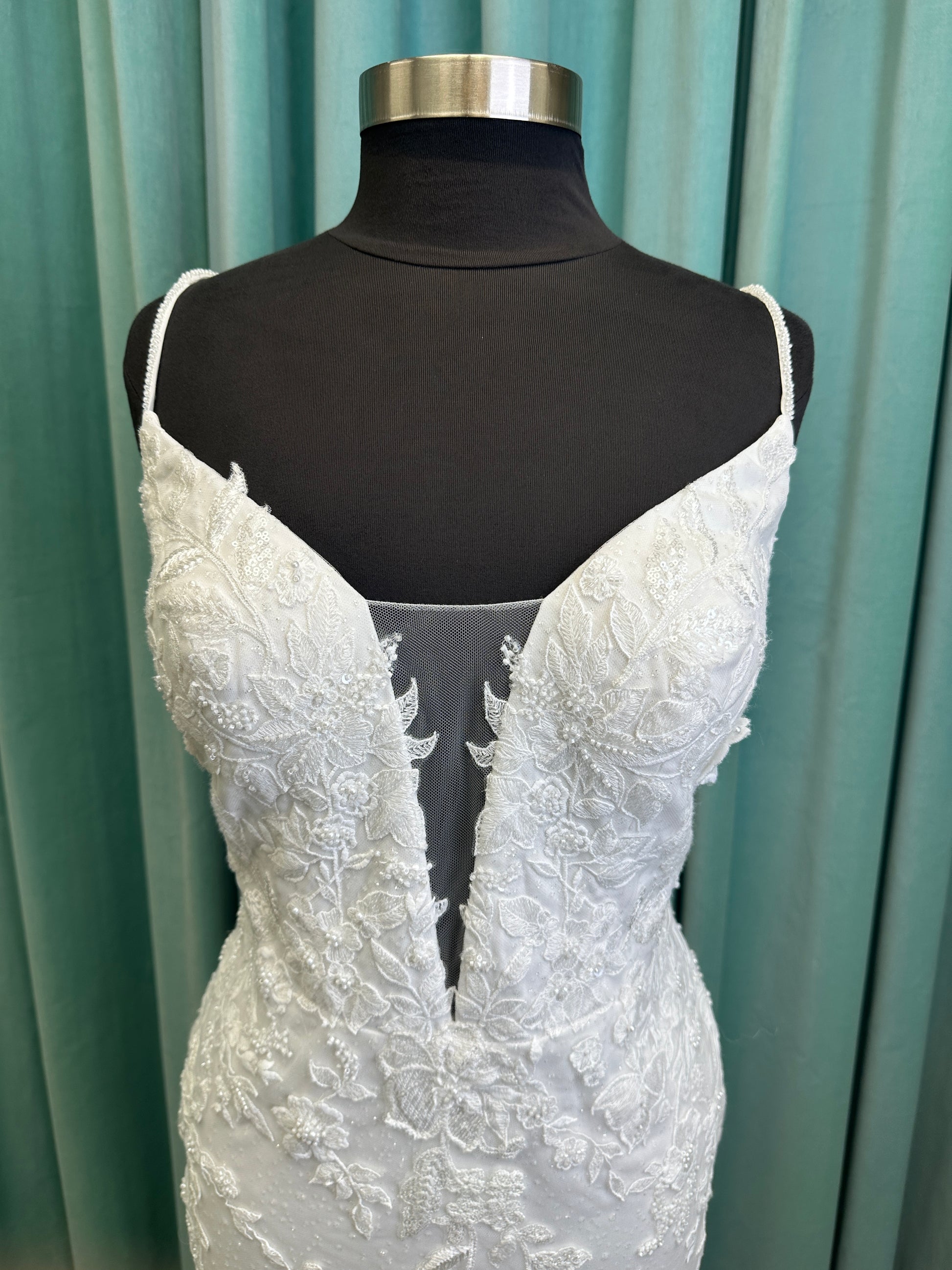 Gracie ivory long sleeve V-neck fit-and-flare wedding dress on mannequin with illusion lace sleeves, fitted silhouette, and scalloped lace cathedral train.
