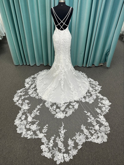 Gracie ivory long sleeve V-neck fit-and-flare wedding dress on mannequin with illusion lace sleeves, fitted silhouette, and scalloped lace cathedral train.
