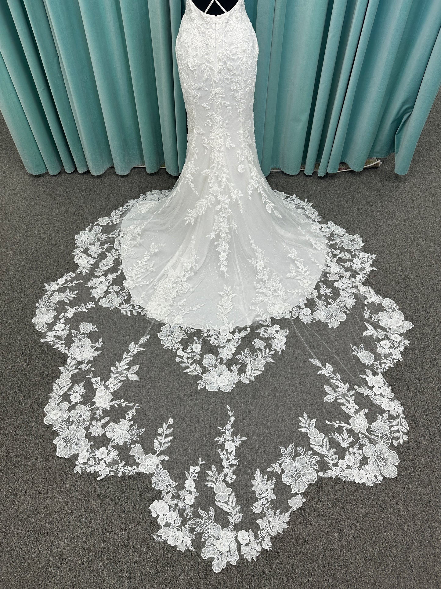 Gracie ivory long sleeve V-neck fit-and-flare wedding dress on mannequin with illusion lace sleeves, fitted silhouette, and scalloped lace cathedral train.
