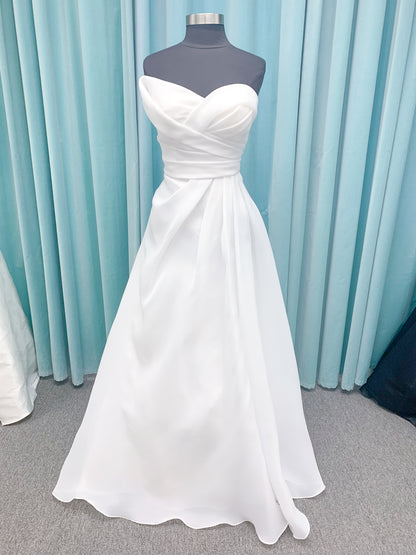 Morilee 2989 Helenia contemporary strapless A-line wedding dress in draped organza with detachable bow and sweeping train.