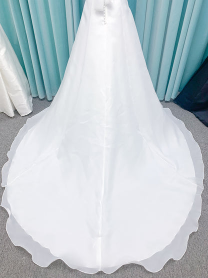 Morilee 2989 Helenia contemporary strapless A-line wedding dress in draped organza with detachable bow and sweeping train.