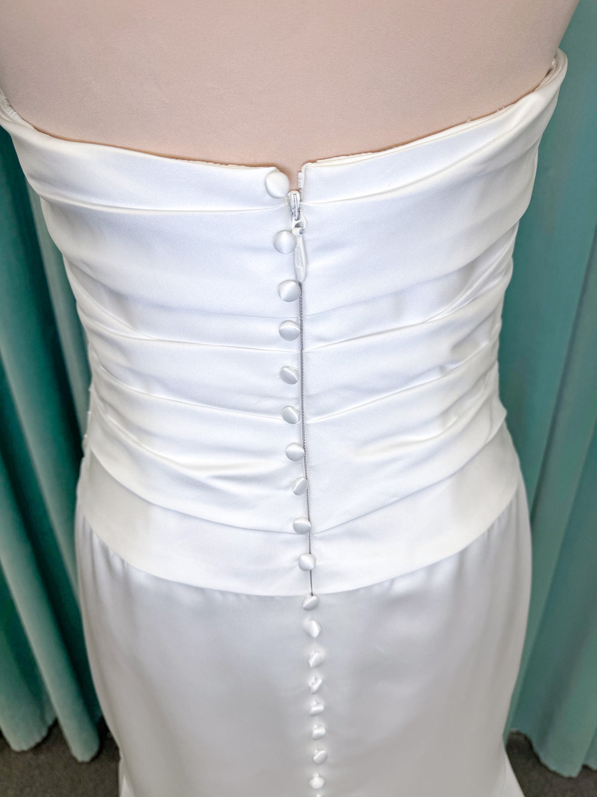 Strapless satin fit-and-flare wedding dress with sweetheart neckline, ruched bodice, fitted hips, and flared chapel-length train.