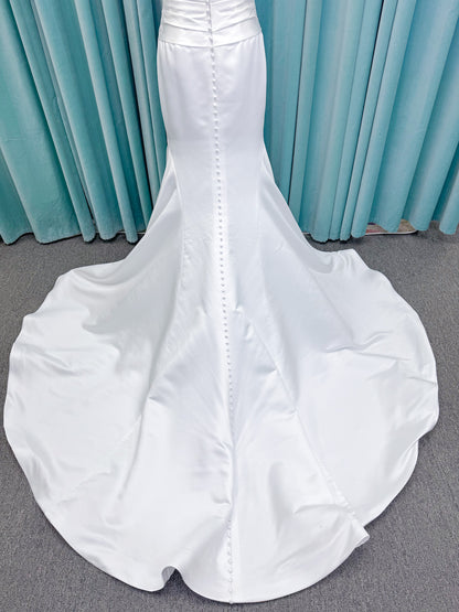 Strapless satin fit-and-flare wedding dress with sweetheart neckline, ruched bodice, fitted hips, and flared chapel-length train.