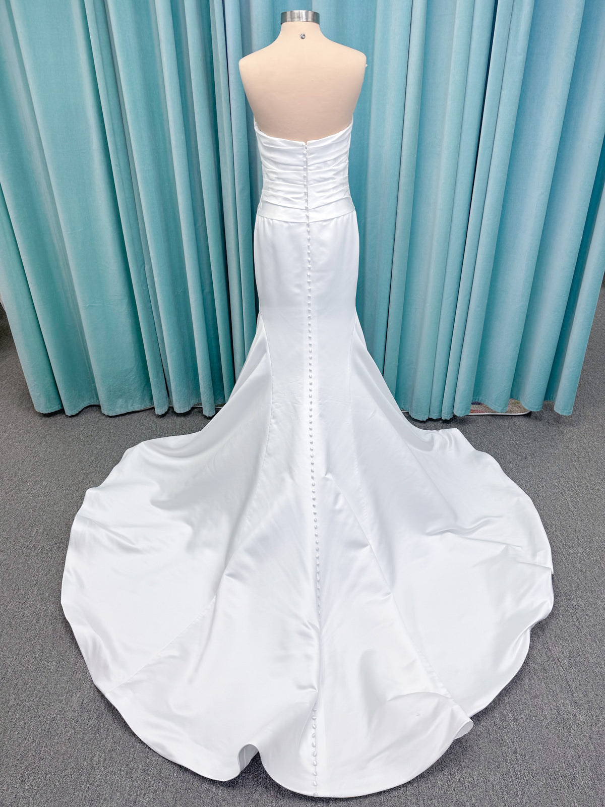 Strapless satin fit-and-flare wedding dress with sweetheart neckline, ruched bodice, fitted hips, and flared chapel-length train.
