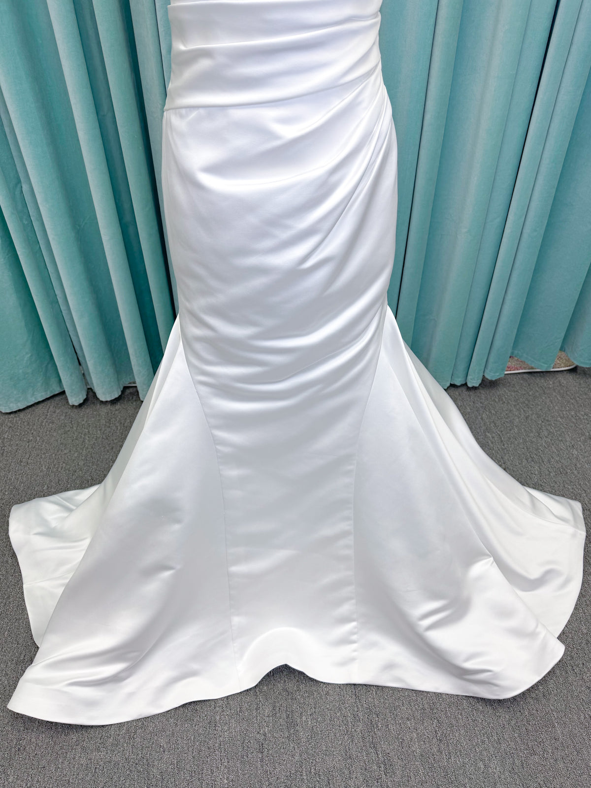 Strapless satin fit-and-flare wedding dress with sweetheart neckline, ruched bodice, fitted hips, and flared chapel-length train.