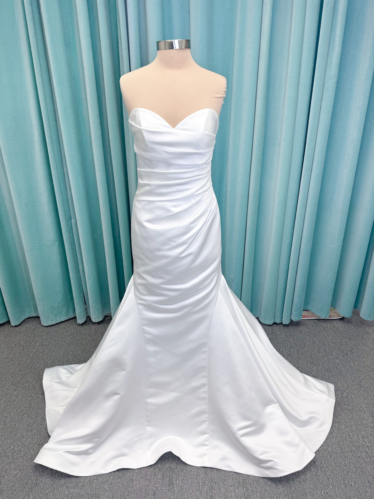 Strapless satin fit-and-flare wedding dress with sweetheart neckline, ruched bodice, fitted hips, and flared chapel-length train.