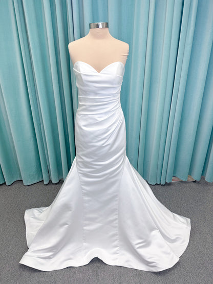 Strapless satin fit-and-flare wedding dress with sweetheart neckline, ruched bodice, fitted hips, and flared chapel-length train.
