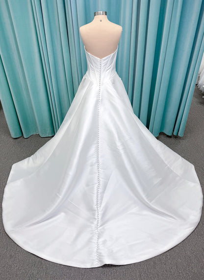 Randy Fenoli Idonna ball gown wedding dress on mannequin with strapless sweetheart neckline, structured mikado bodice, basque waist, covered back buttons, and side pockets