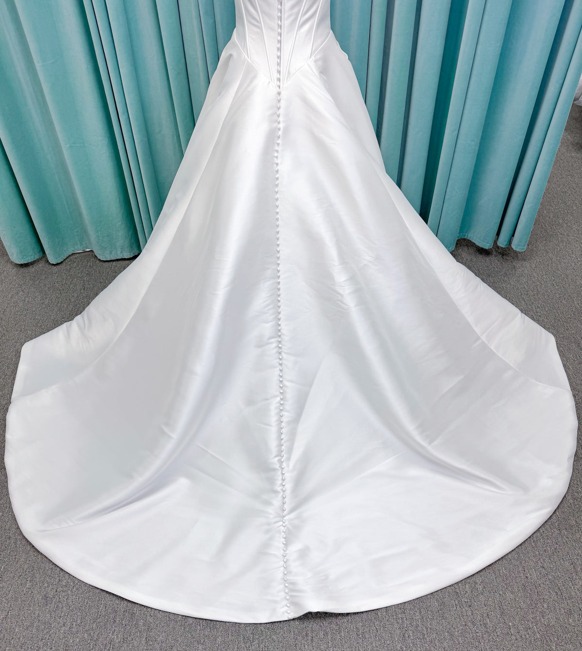 Randy Fenoli Idonna ball gown wedding dress on mannequin with strapless sweetheart neckline, structured mikado bodice, basque waist, covered back buttons, and side pockets