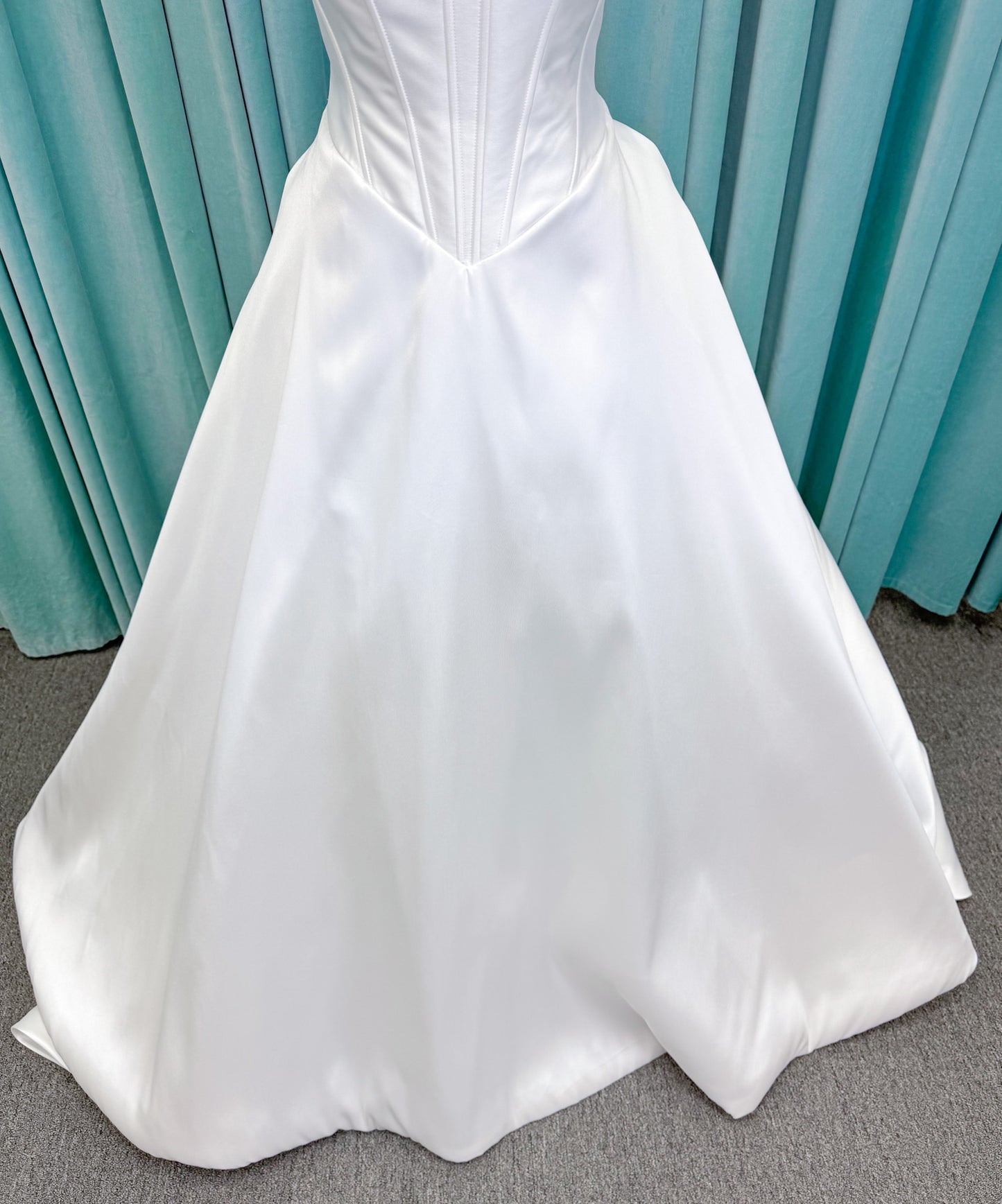 Randy Fenoli Idonna ball gown wedding dress on mannequin with strapless sweetheart neckline, structured mikado bodice, basque waist, covered back buttons, and side pockets