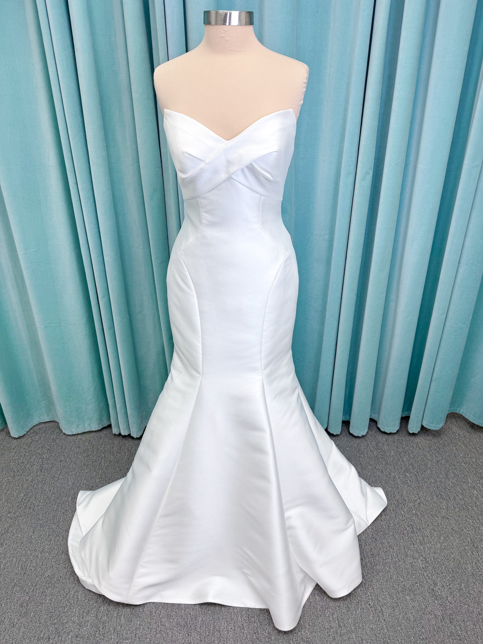 Randy Fenoli Imani fit and flare wedding dress on mannequin with strapless sweetheart neckline, structured mikado bodice, and oversized back bow with covered buttons