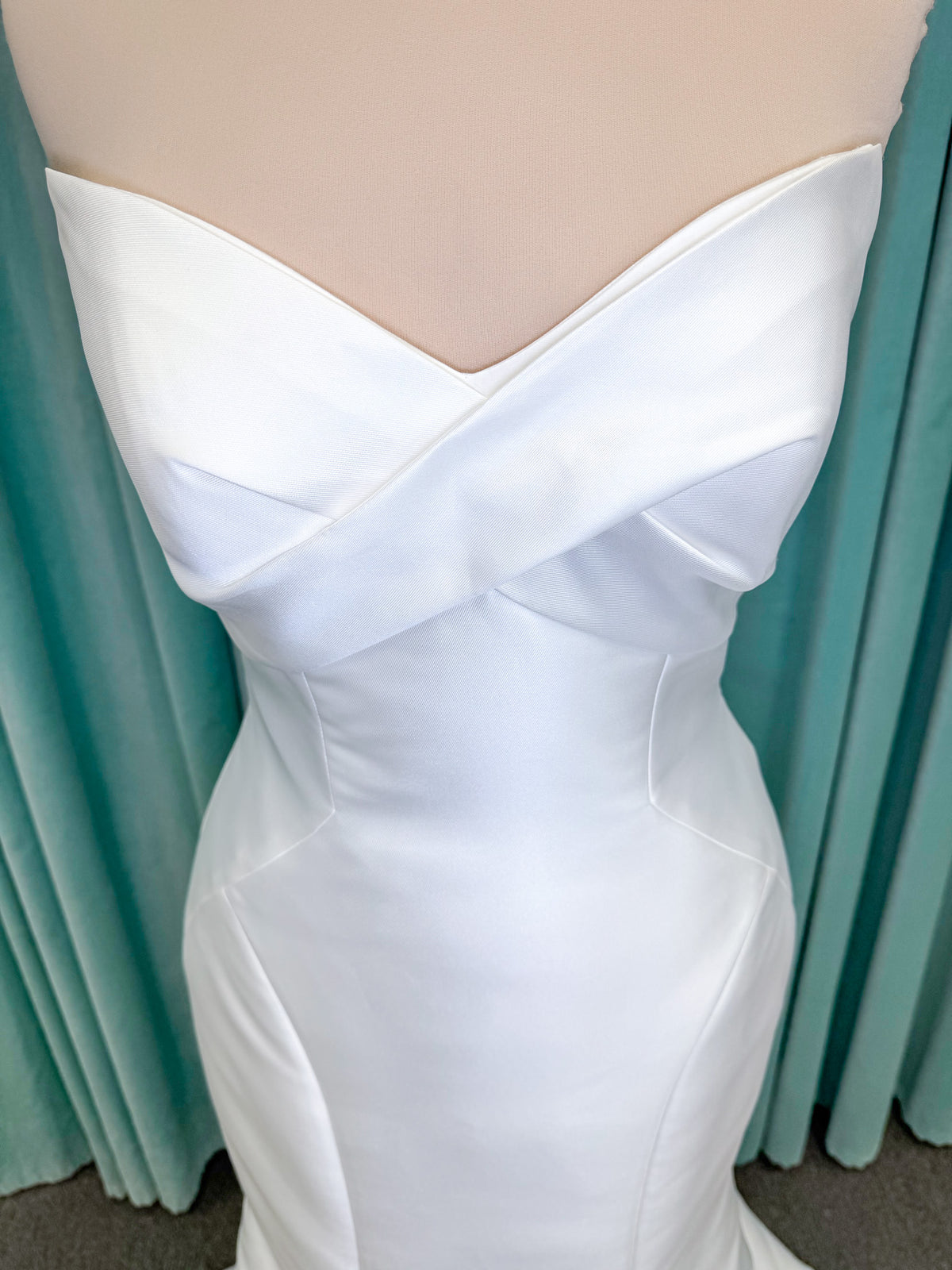 Randy Fenoli Imani fit and flare wedding dress on mannequin with strapless sweetheart neckline, structured mikado bodice, and oversized back bow with covered buttons