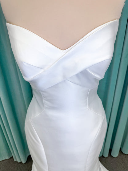 Randy Fenoli Imani fit and flare wedding dress on mannequin with strapless sweetheart neckline, structured mikado bodice, and oversized back bow with covered buttons