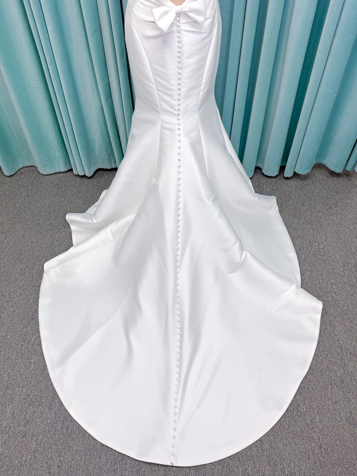 Randy Fenoli Imani fit and flare wedding dress on mannequin with strapless sweetheart neckline, structured mikado bodice, and oversized back bow with covered buttons