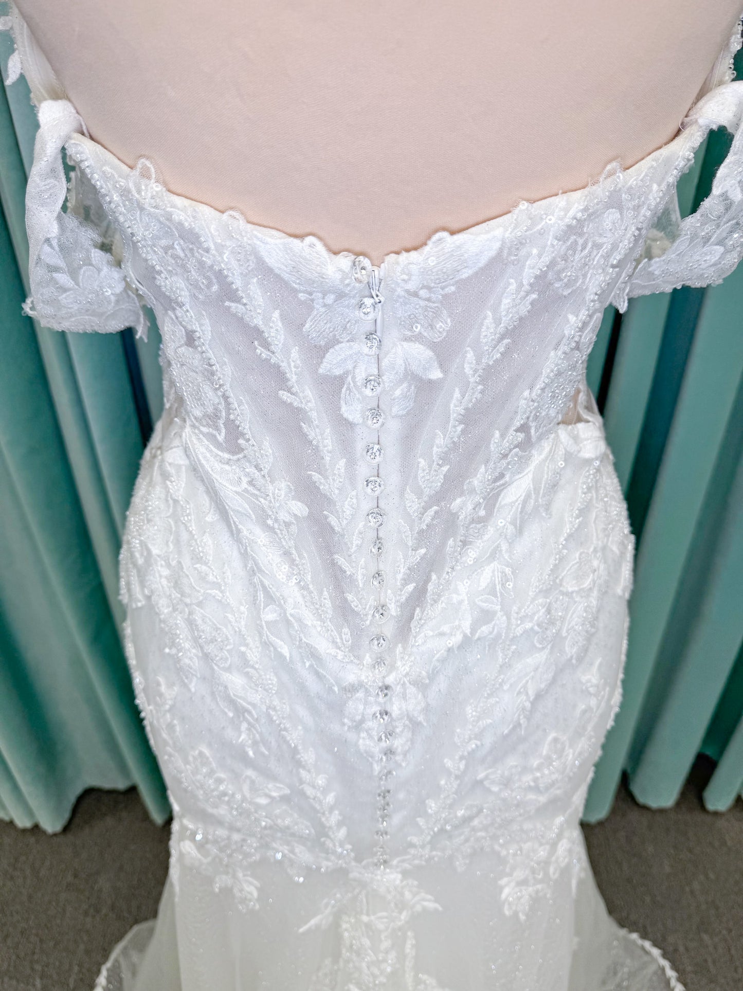 Randy Fenoli Jillian fit and flare wedding dress on mannequin with strapless sweetheart neckline, beaded lace appliqué, detachable off-the-shoulder straps, and glitter tulle skirt