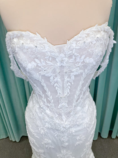 Randy Fenoli Jillian fit and flare wedding dress on mannequin with strapless sweetheart neckline, beaded lace appliqué, detachable off-the-shoulder straps, and glitter tulle skirt