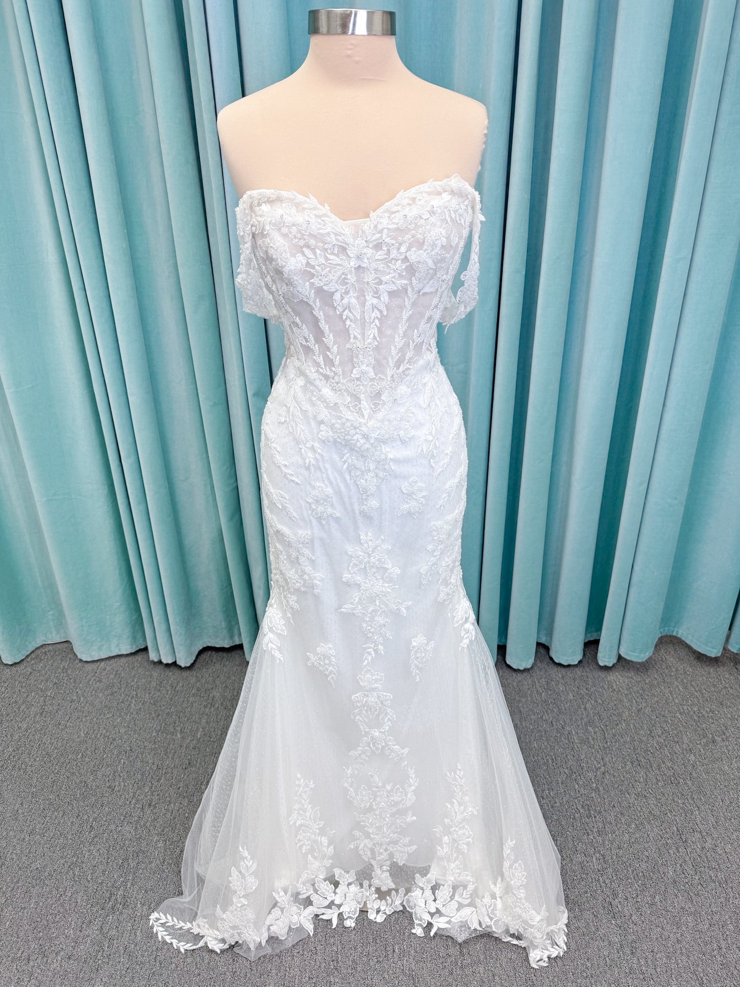 Randy Fenoli Jillian fit and flare wedding dress on mannequin with strapless sweetheart neckline, beaded lace appliqué, detachable off-the-shoulder straps, and glitter tulle skirt