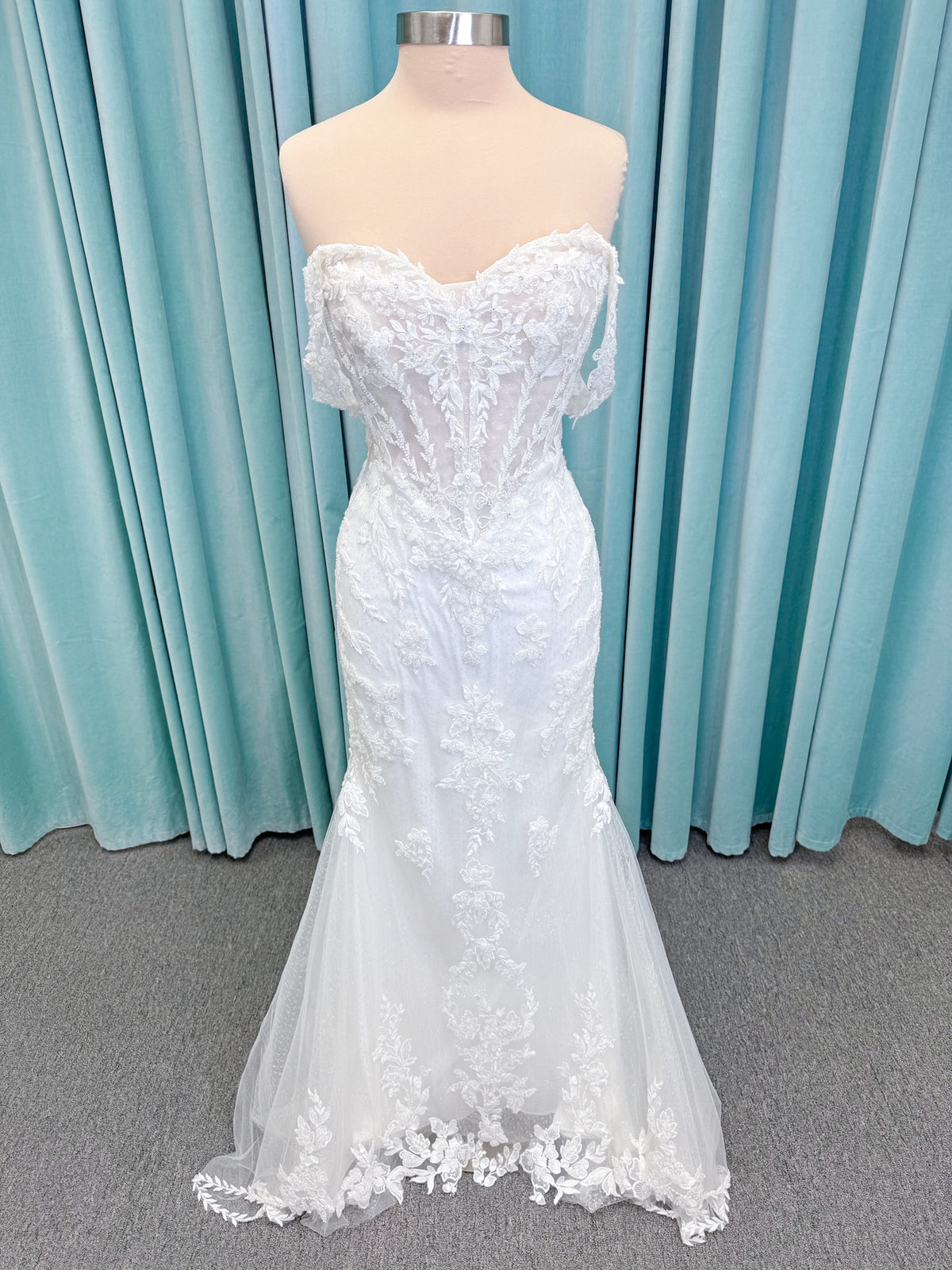 Randy Fenoli Jillian fit and flare wedding dress on mannequin with strapless sweetheart neckline, beaded lace appliqué, detachable off-the-shoulder straps, and glitter tulle skirt