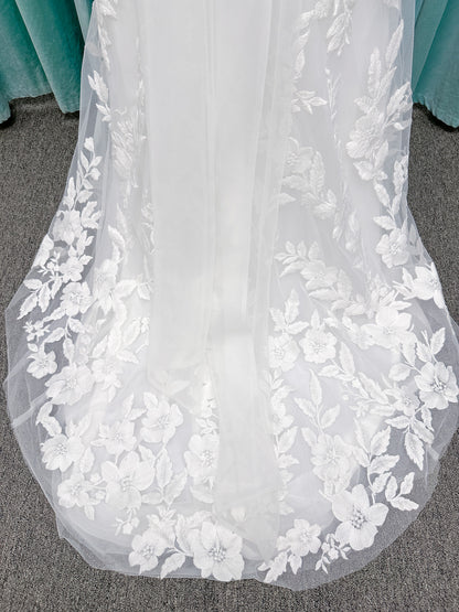 Morilee 2936 Kali fit and flare wedding dress on mannequin with high neckline, threadwork floral appliqued tulle, and detachable organza bow blouson sleeves