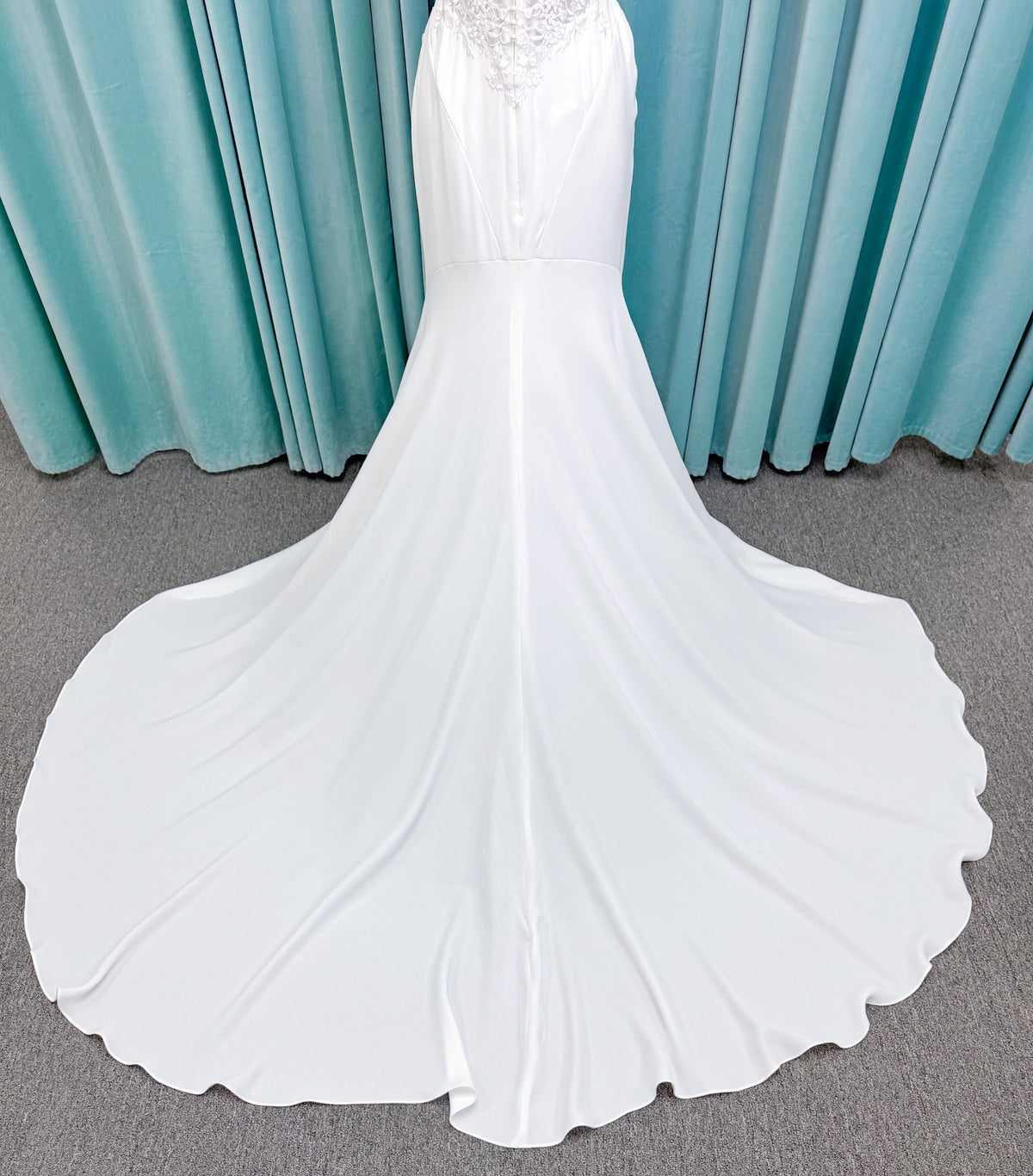 Randy Fenoli Kitty fit and flare wedding dress on mannequin with strapless sweetheart neckline, floral lace appliqué, and fluid crepe skirt