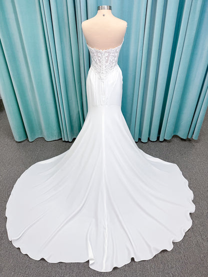 Randy Fenoli Kitty fit and flare wedding dress on mannequin with strapless sweetheart neckline, floral lace appliqué, and fluid crepe skirt
