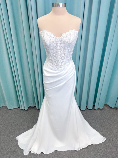 Randy Fenoli Kitty fit and flare wedding dress on mannequin with strapless sweetheart neckline, floral lace appliqué, and fluid crepe skirt
