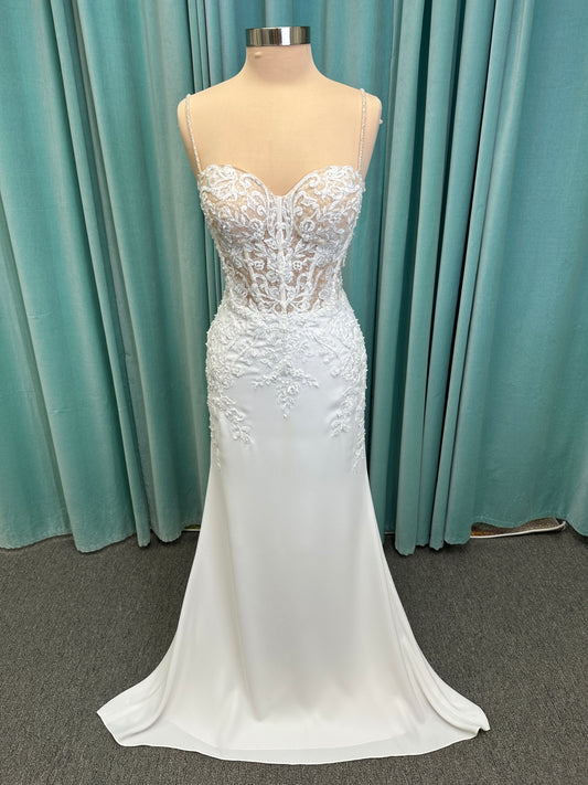 Liena ivory spaghetti strap wedding dress on mannequin with illusion corset bodice, floral lace appliqués, sweetheart neckline, and crepe skirt.
