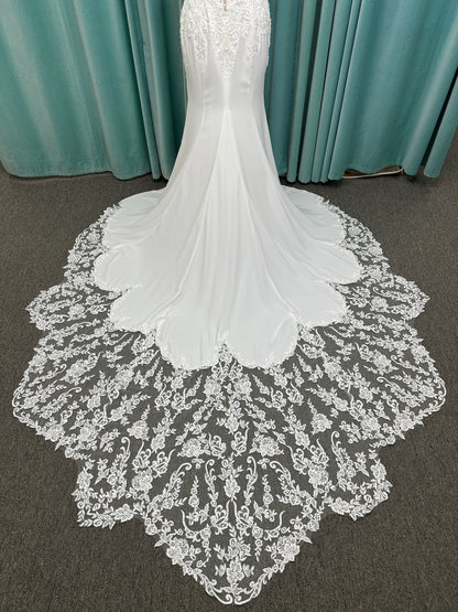 Liena ivory spaghetti strap wedding dress on mannequin with illusion corset bodice, floral lace appliqués, sweetheart neckline, and crepe skirt.
