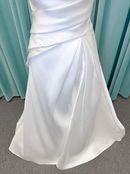 Moonlight Bridal J6978 Livana A-line wedding dress on mannequin with strapless scoop neckline, ruched mikado bodice, asymmetrical draped waist, high front slit, and chapel train