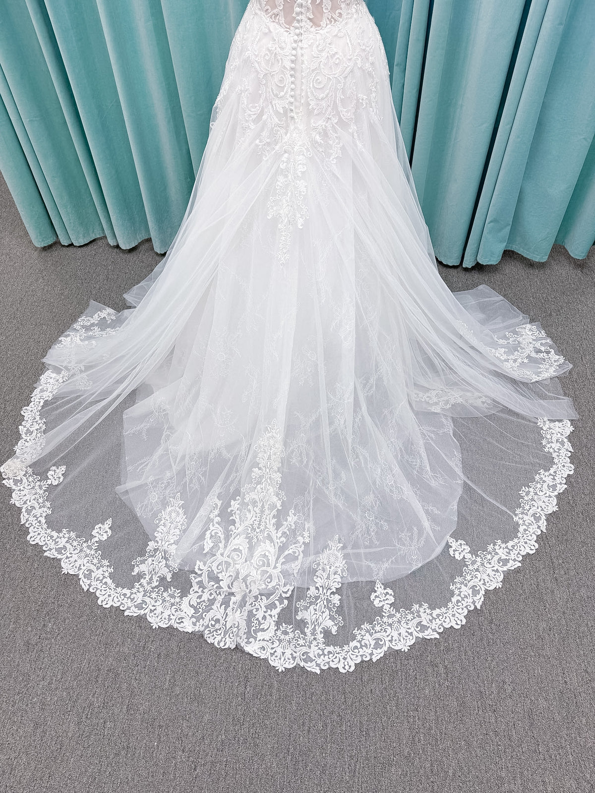Moonlight Bridal J6972 Lunetta A-line wedding dress on mannequin with strapless soft sweetheart neckline, beaded lace appliques over tulle and Chantilly lace, drop waist, and scalloped applique sweep train