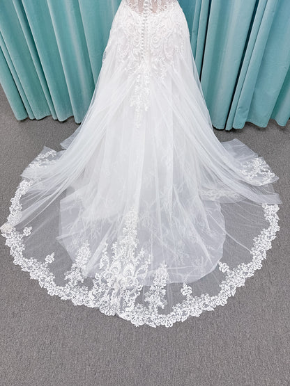 Moonlight Bridal J6972 Lunetta A-line wedding dress on mannequin with strapless soft sweetheart neckline, beaded lace appliques over tulle and Chantilly lace, drop waist, and scalloped applique sweep train