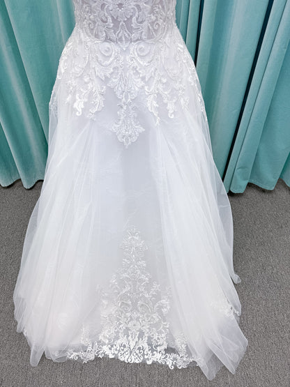 Moonlight Bridal J6972 Lunetta A-line wedding dress on mannequin with strapless soft sweetheart neckline, beaded lace appliques over tulle and Chantilly lace, drop waist, and scalloped applique sweep train