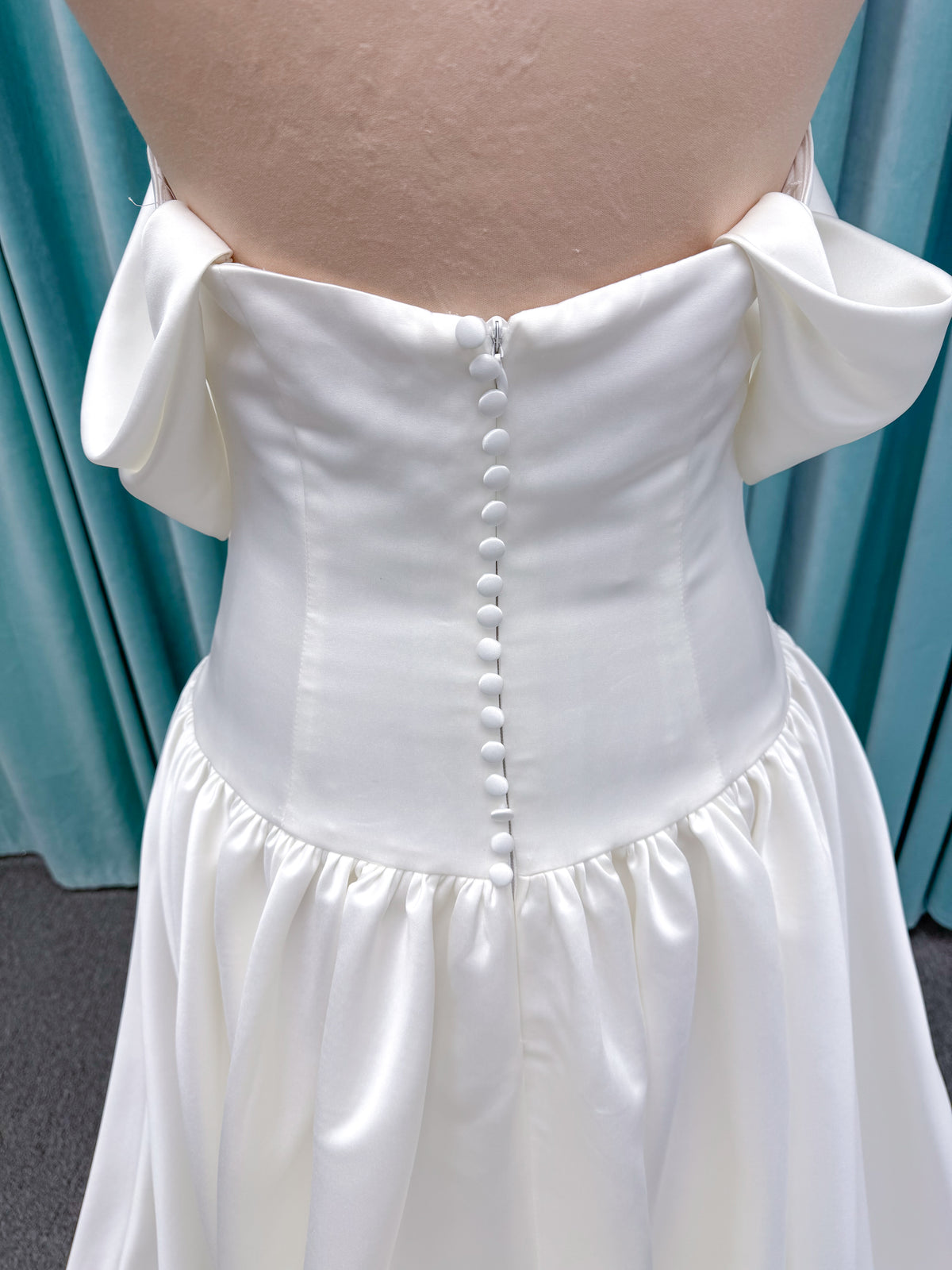 Moonlight Bridal J6956 Mahina ballgown wedding dress on mannequin with scoop neckline, detachable off-the-shoulder swag sleeves, drop waist, ruched shimmering satin skirt, and chapel train with horsehair hem