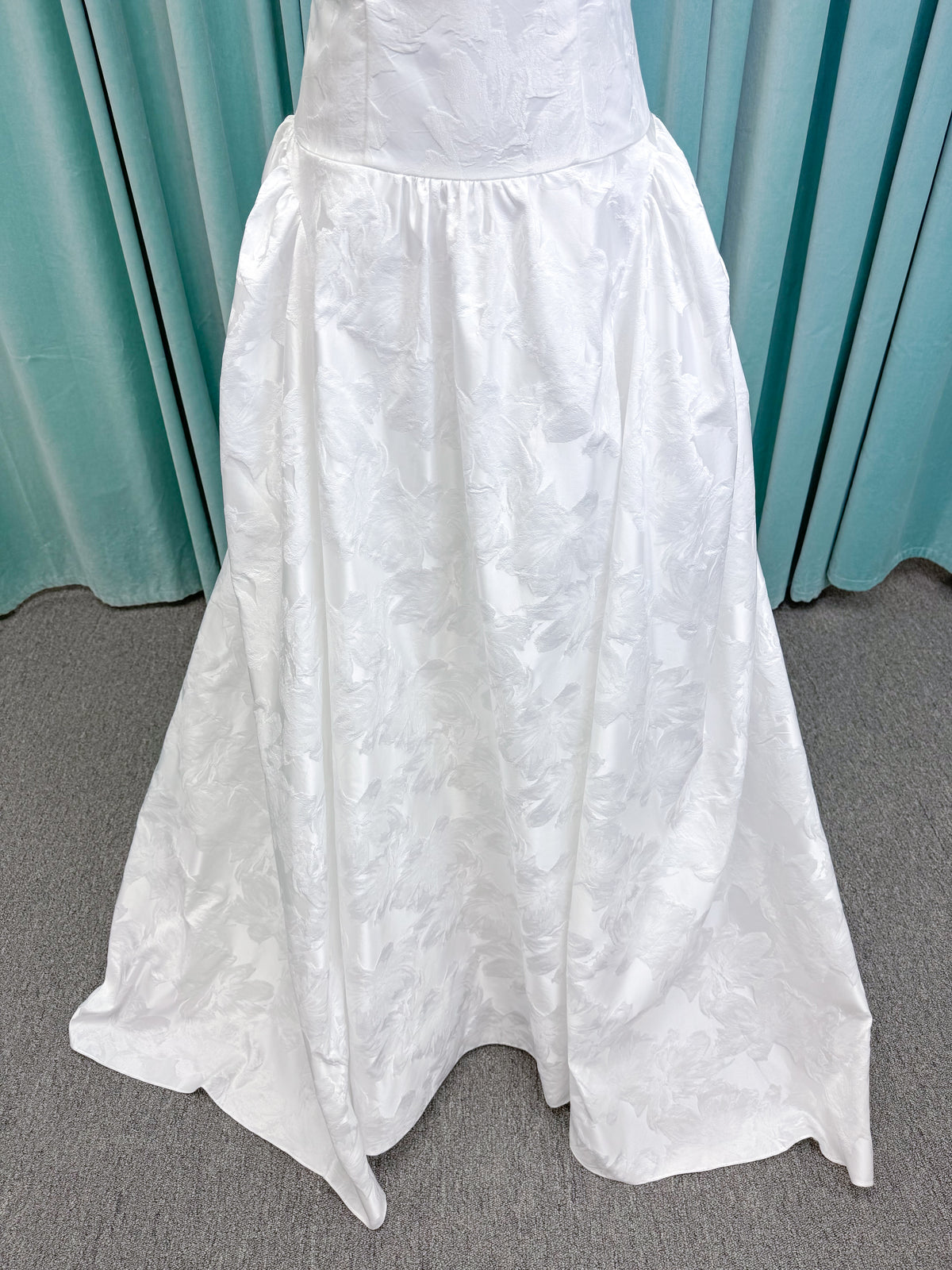 Moonlight Bridal J6994 Marama ballgown wedding dress on mannequin with strapless scoop neckline, textured satin jacquard, fitted drop-waist bodice, detachable short bow sleeves, full skirt, and sweep train