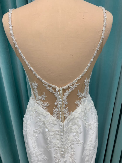 Marjorie ivory spaghetti strap wedding dress on mannequin with illusion corset bodice, floral lace appliqués, and scoop neckline.
