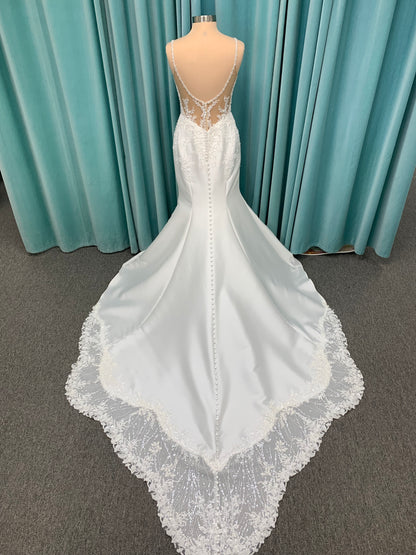 Marjorie ivory spaghetti strap wedding dress on mannequin with illusion corset bodice, floral lace appliqués, and scoop neckline.
